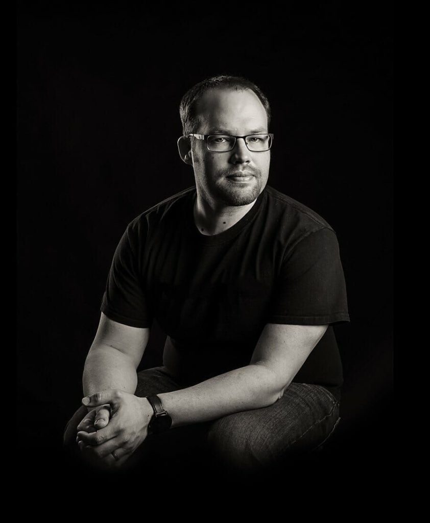 Black and white studio portrait of Jon Adams, a professional photographer providing affordable wedding photographer services in Vermont.